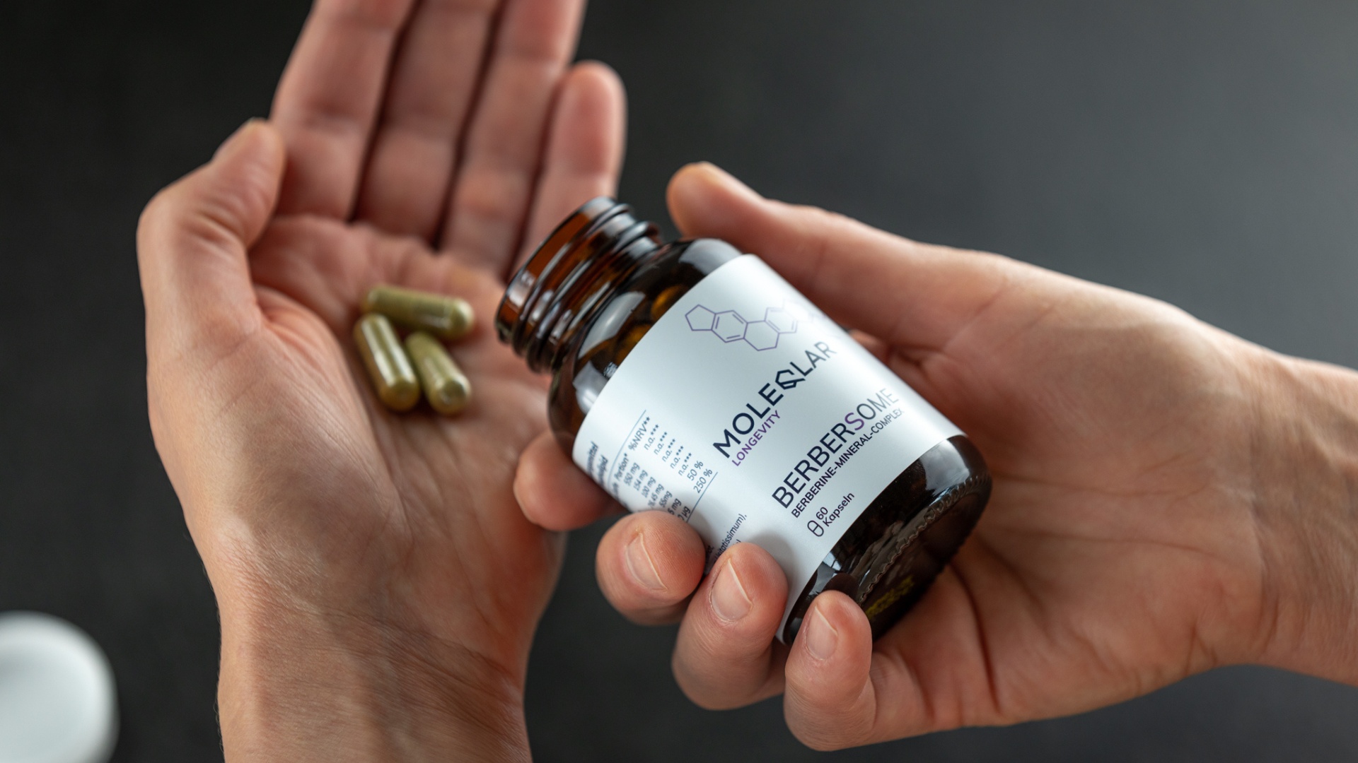 Berbersome capsules in one hand.